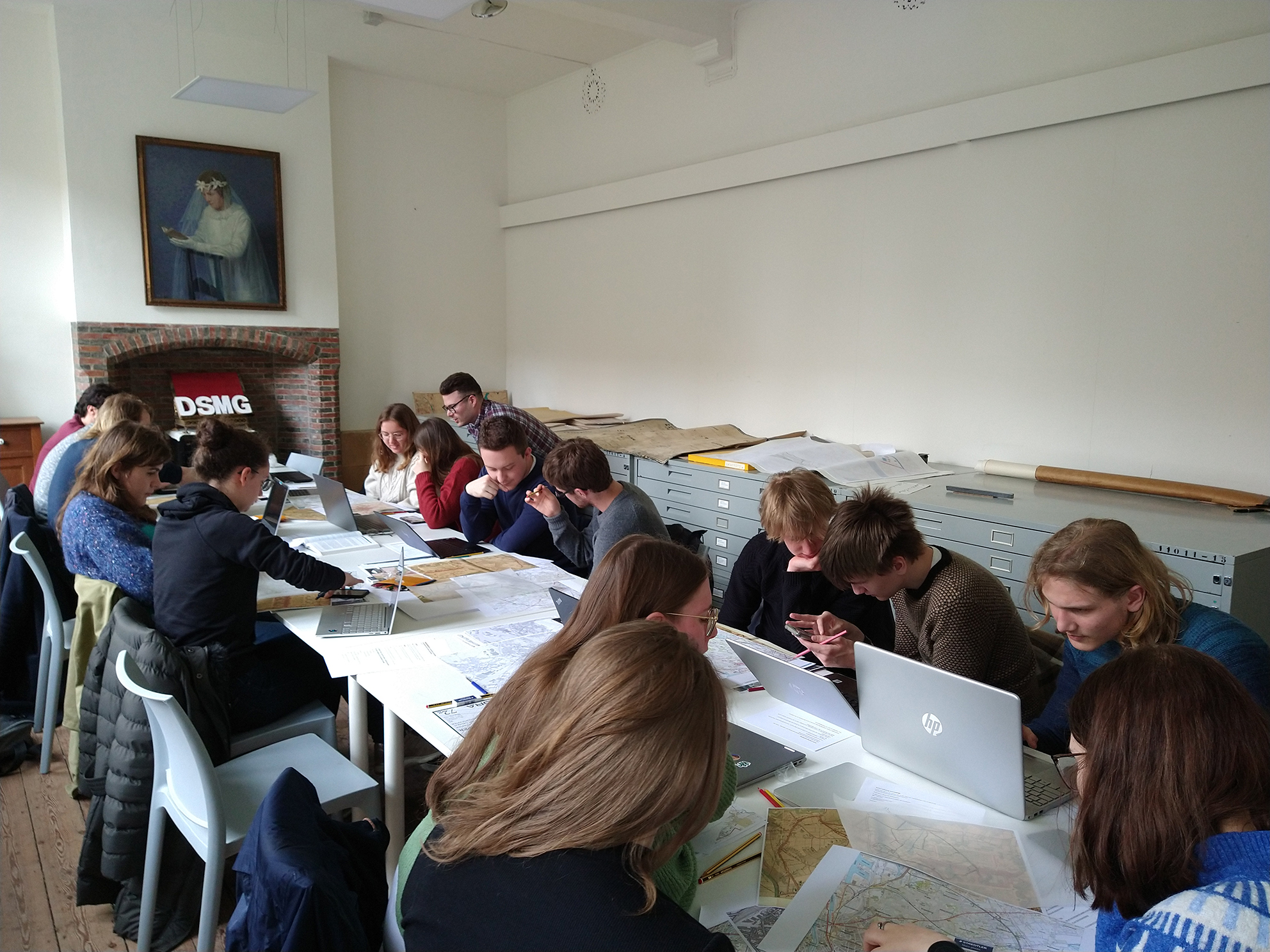 Studenten bestuderen kaarten in het DSMG